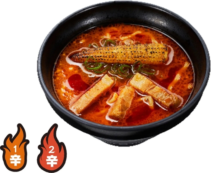黒い器に入った、トウモロコシとチャーシューがトッピングされたラーメン。辛さを表すマークが2つ表示されている。