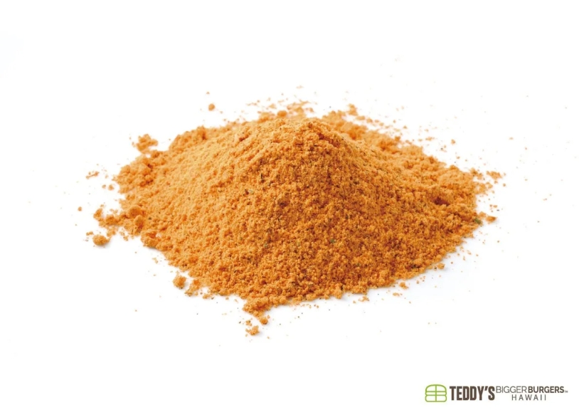 白い背景にオレンジ色の粉末状のスパイスの山。