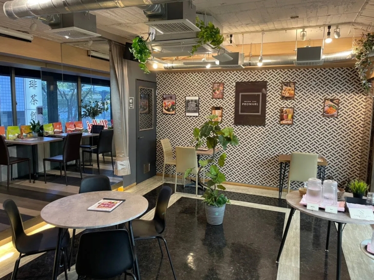 店内を写した写真。テーブル席と壁の装飾が特徴的で、観葉植物が配置されている。