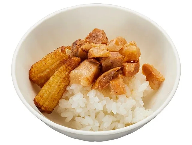 白い器に入ったご飯の上に、角切りの肉とベビーコーンが乗っている料理の写真です。