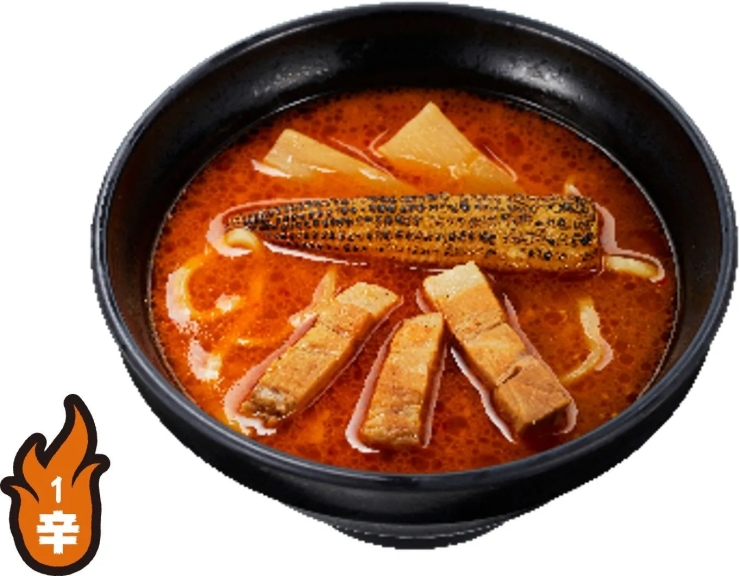 黒い器に入ったラーメン。スープは赤く、トウモロコシ、チャーシュー、メンマのようなものが入っている。辛さを表すマークがついている。