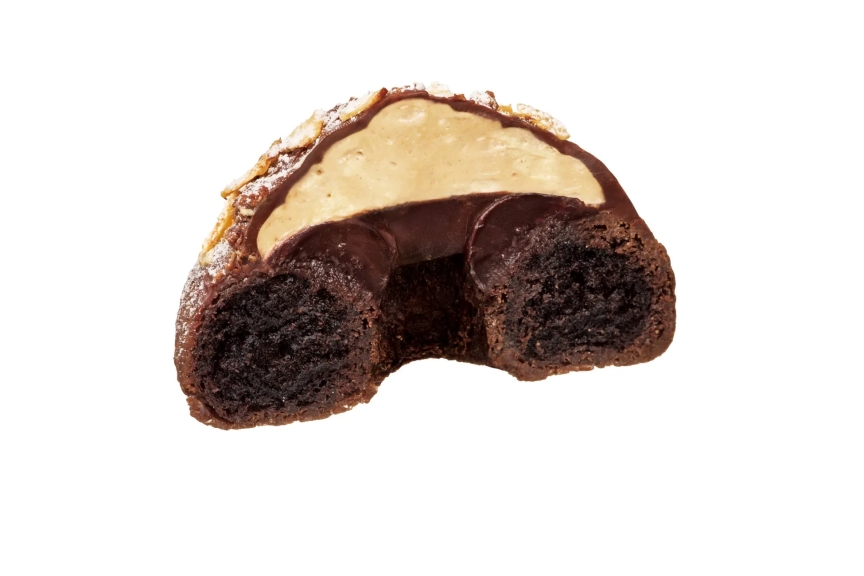 チョコレートケーキの断面図。チョコレートでコーティングされ、クリームがトッピングされている。アーモンドスライスが添えられている。