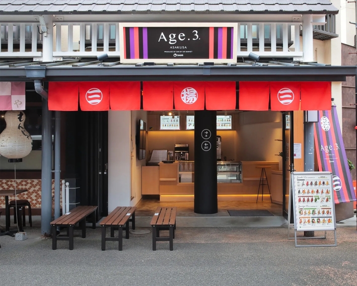 浅草にあるカフェ「Age.3」の外観。赤い暖簾、メニュー看板、ベンチが設置されている。