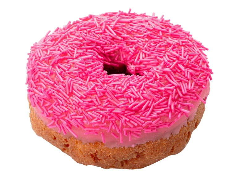ピンク色のドーナツ。ピンク色のアイシングとピンク色のスプリンクルで覆われている。