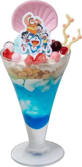 ドラえもんのキャラクターが飾られたパフェ。青いゼリーやクリーム、フルーツが層になっており、見た目も華やか。