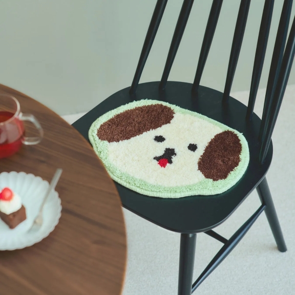 犬の顔の形をしたクッションが置かれた黒い椅子