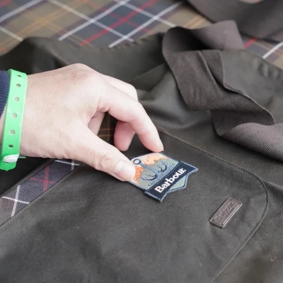 手でバブアーのパッチを指している様子