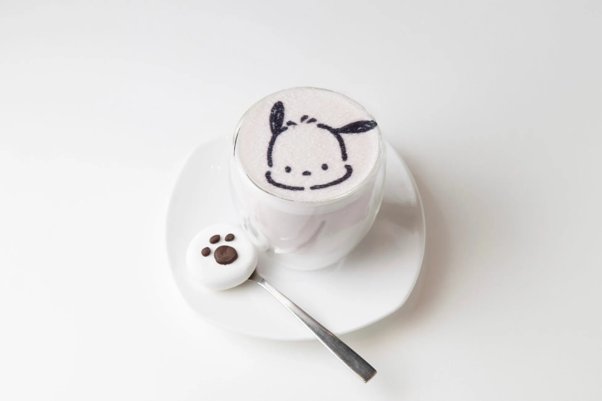 ポチャッコの顔が描かれたホットミルクと、肉球の形をしたマシュマロが乗っている可愛らしいドリンクの写真です。