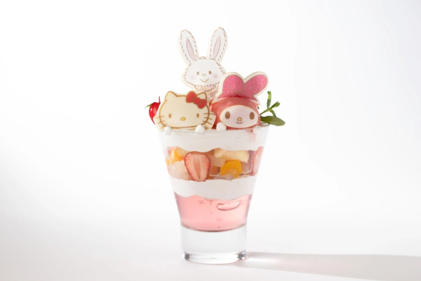 ハローキティとマイメロディ、ウサギのクッキーがトッピングされたパフェ。ピンク色のゼリー、フルーツ、クリームが層になっている。