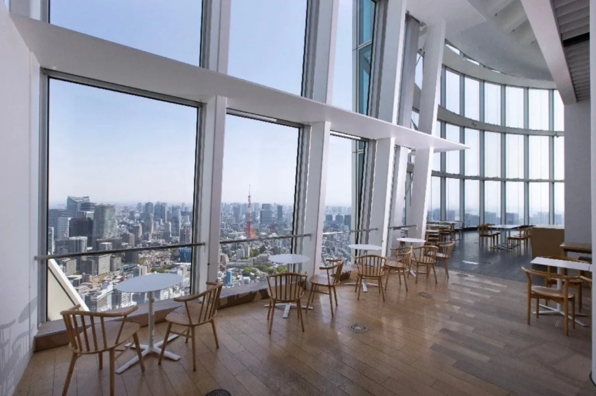 東京の街並みを一望できる展望レストランの様子。窓際のテーブル席からは東京タワーが見え、洗練された雰囲気の中で食事を楽しめる。