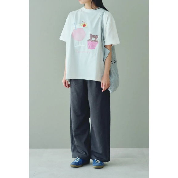 白いTシャツにイラストが描かれた女性の全身写真