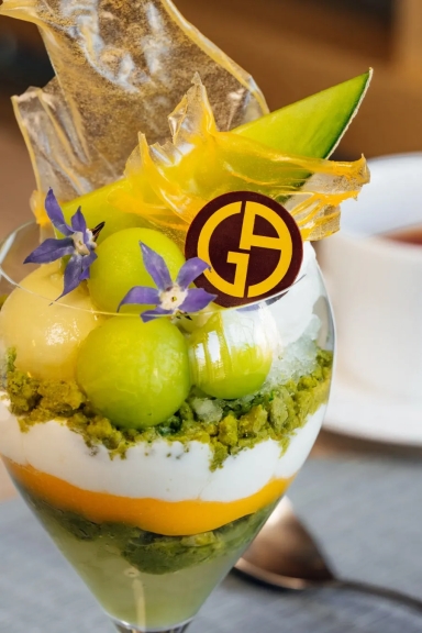 メロン、クリーム、花が飾られたパフェのクローズアップ