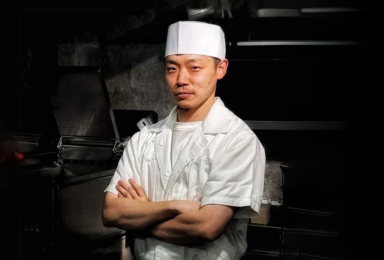 料理人が腕を組んで立っている写真