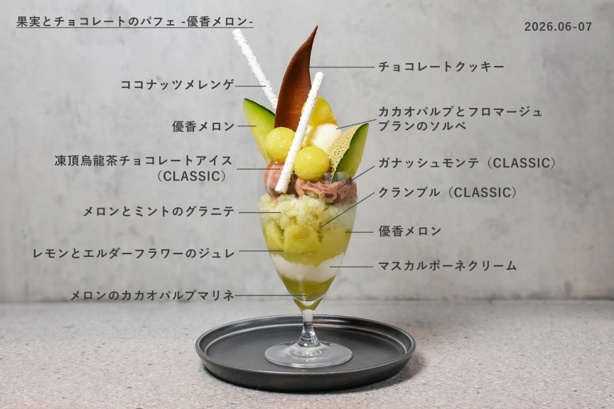 パフェの写真。グラスに入ったパフェは、メロン、チョコレート、クランブル、アイスクリームなど、さまざまな層で構成されている。上部にはココナッツメレンゲとチョコレートクッキーが飾られ、見た目も華やかである。
