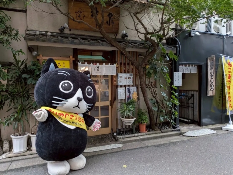 「ねこまつり」の黒猫マスコットが立つ老舗とんかつ店
